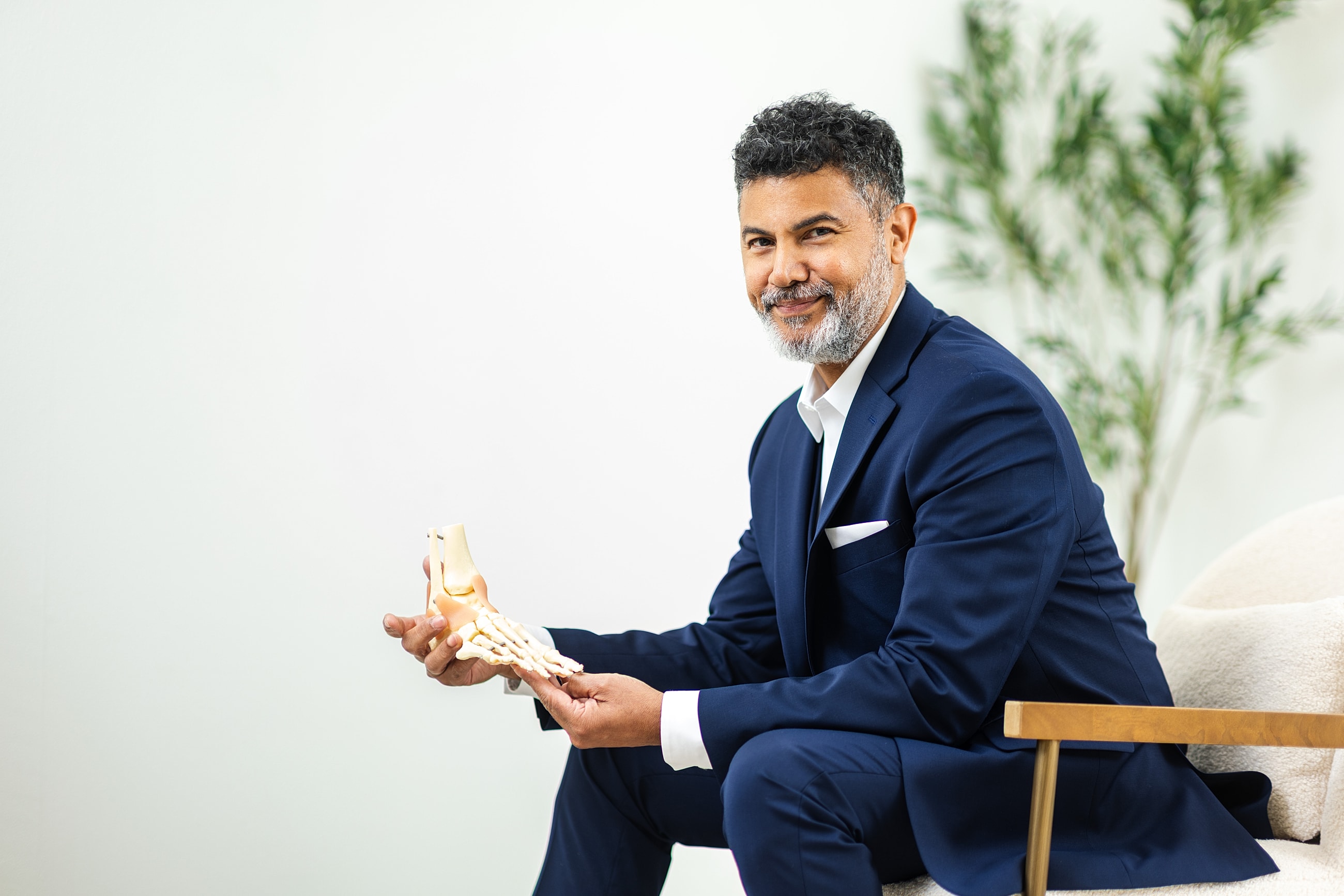 Man in suit holding foot model.