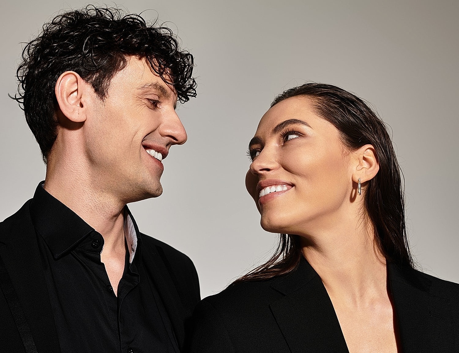Couple smiling at each other in formal attire.