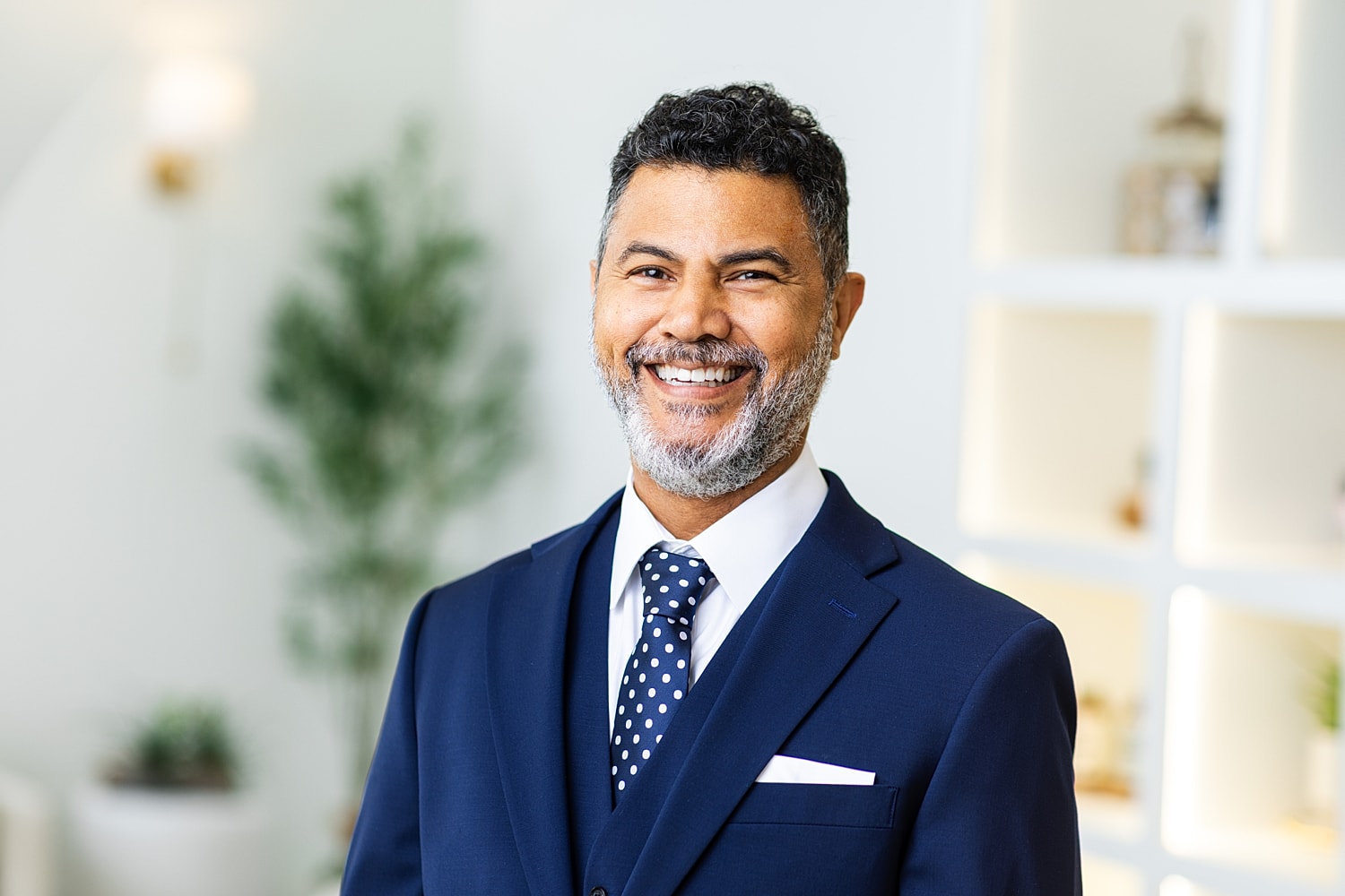 Smiling man in medical scrubs against white background.