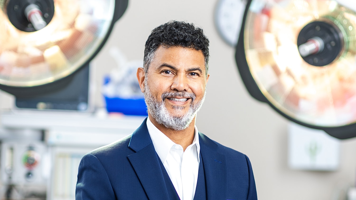 Smiling professional in medical setting with equipment.