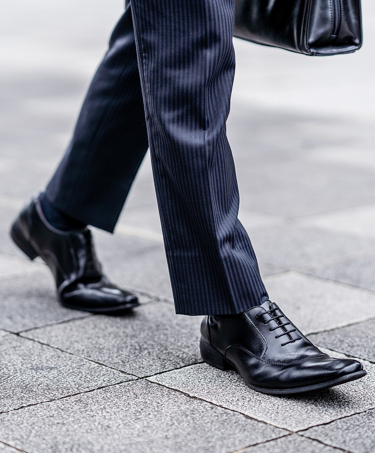 Stylish woman in high heels near black car.
