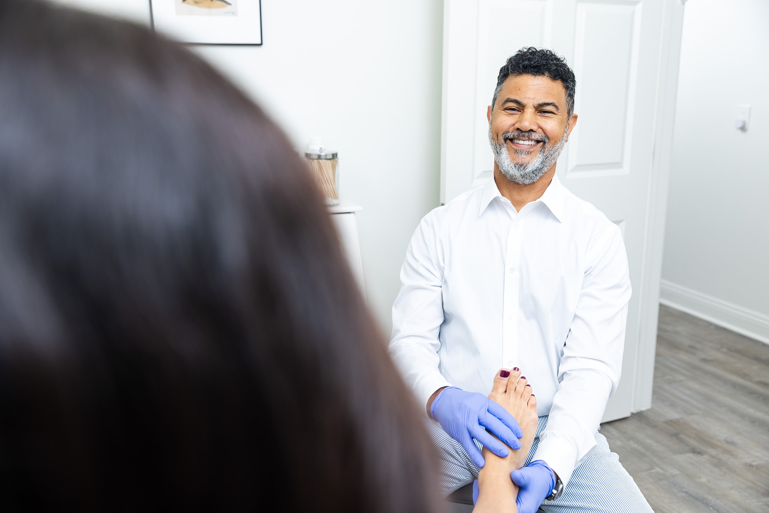 Podiatrist examining patient's foot in clinic.