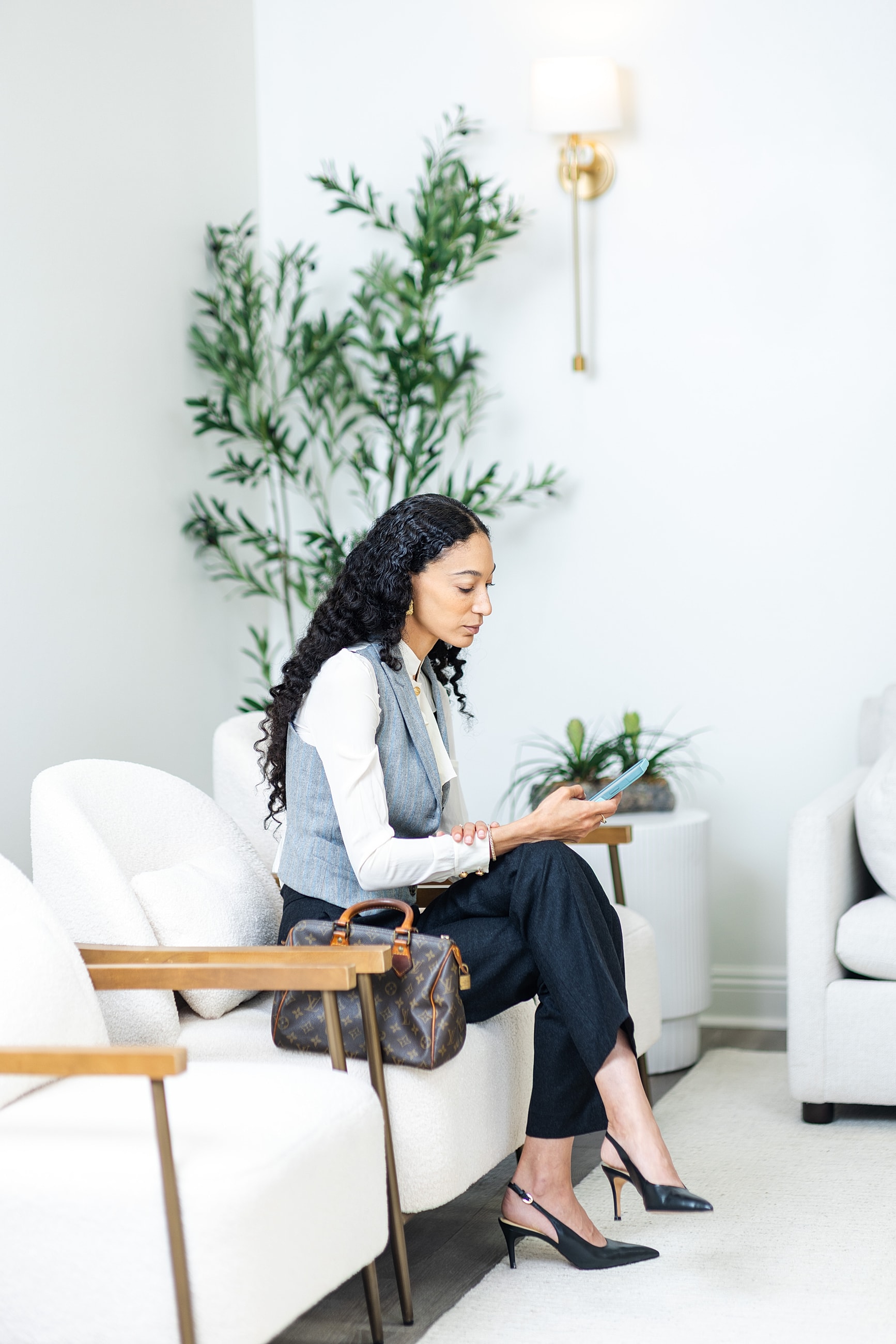 Woman sitting, using smartphone in waiting area.