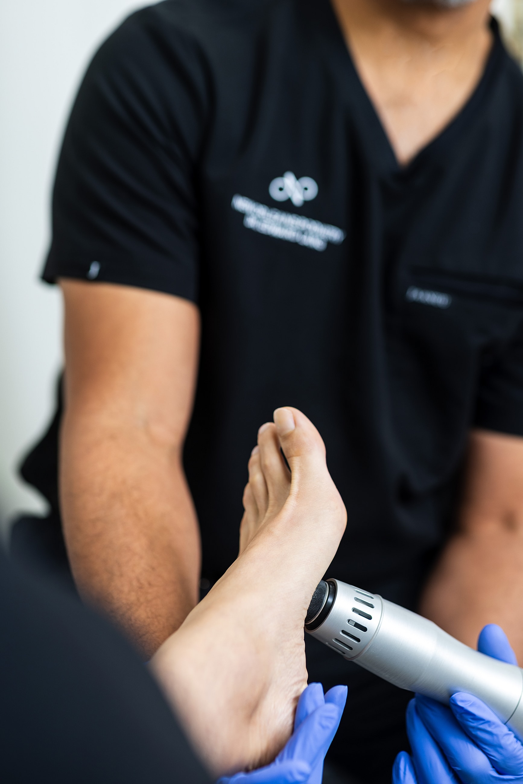 Foot treatment with medical device in clinic.