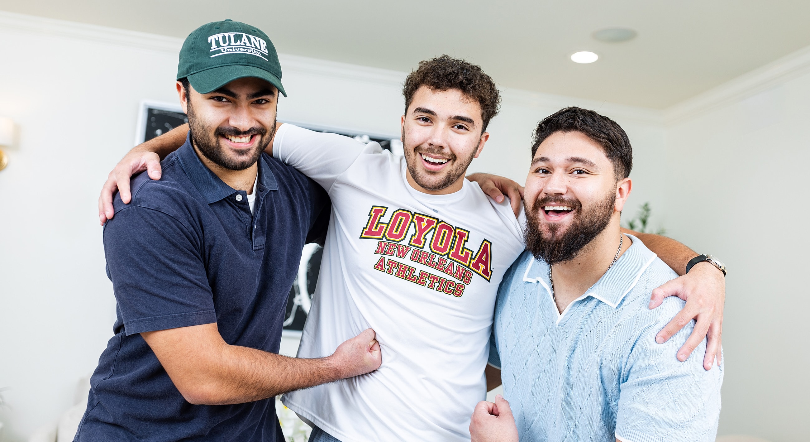 Three friends posing happily together indoors.