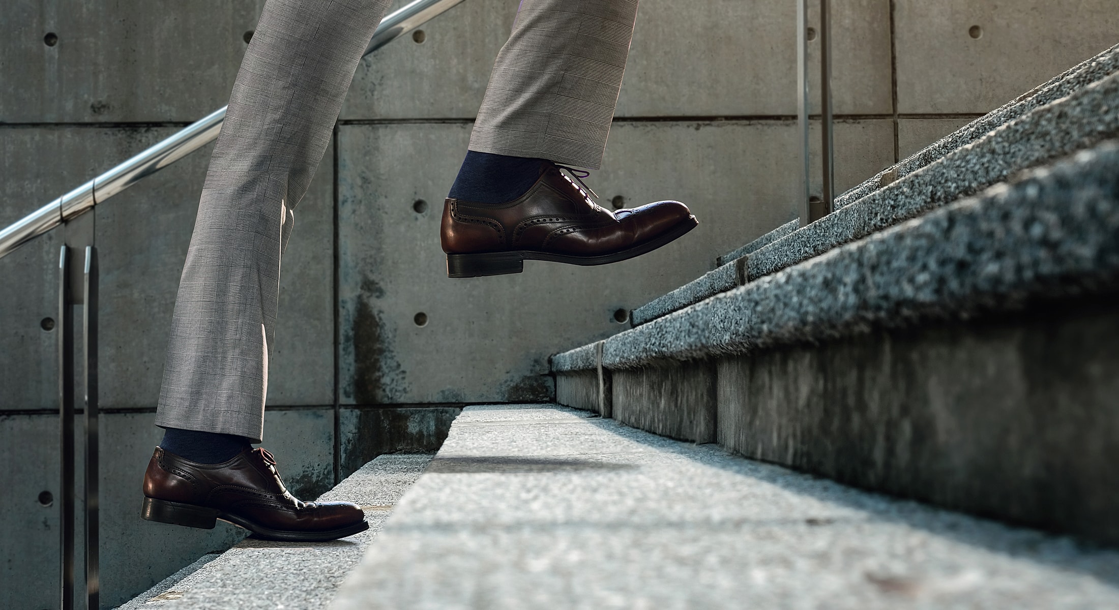 Business professional walking up stone stairs.