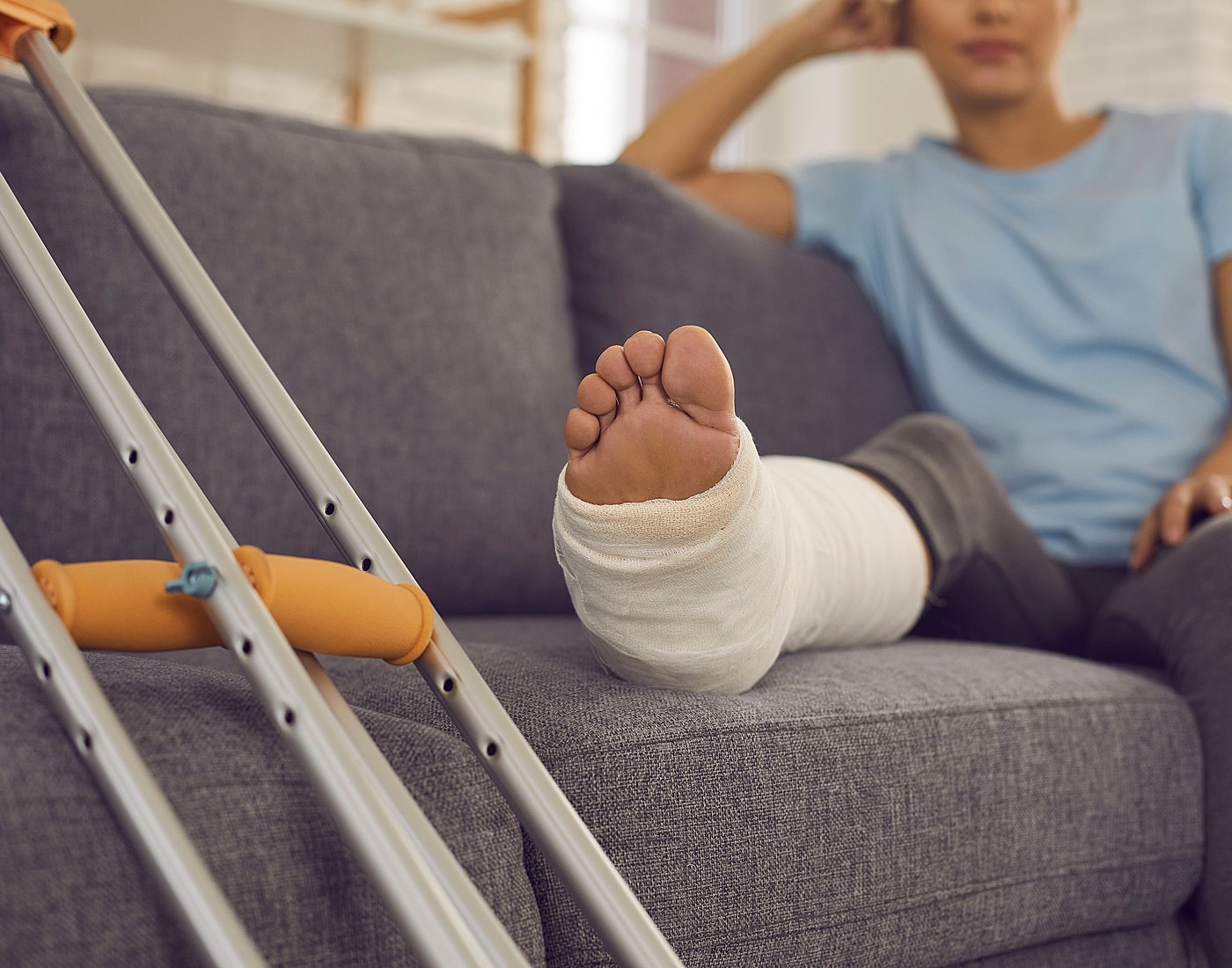 Person resting on couch with leg injury.