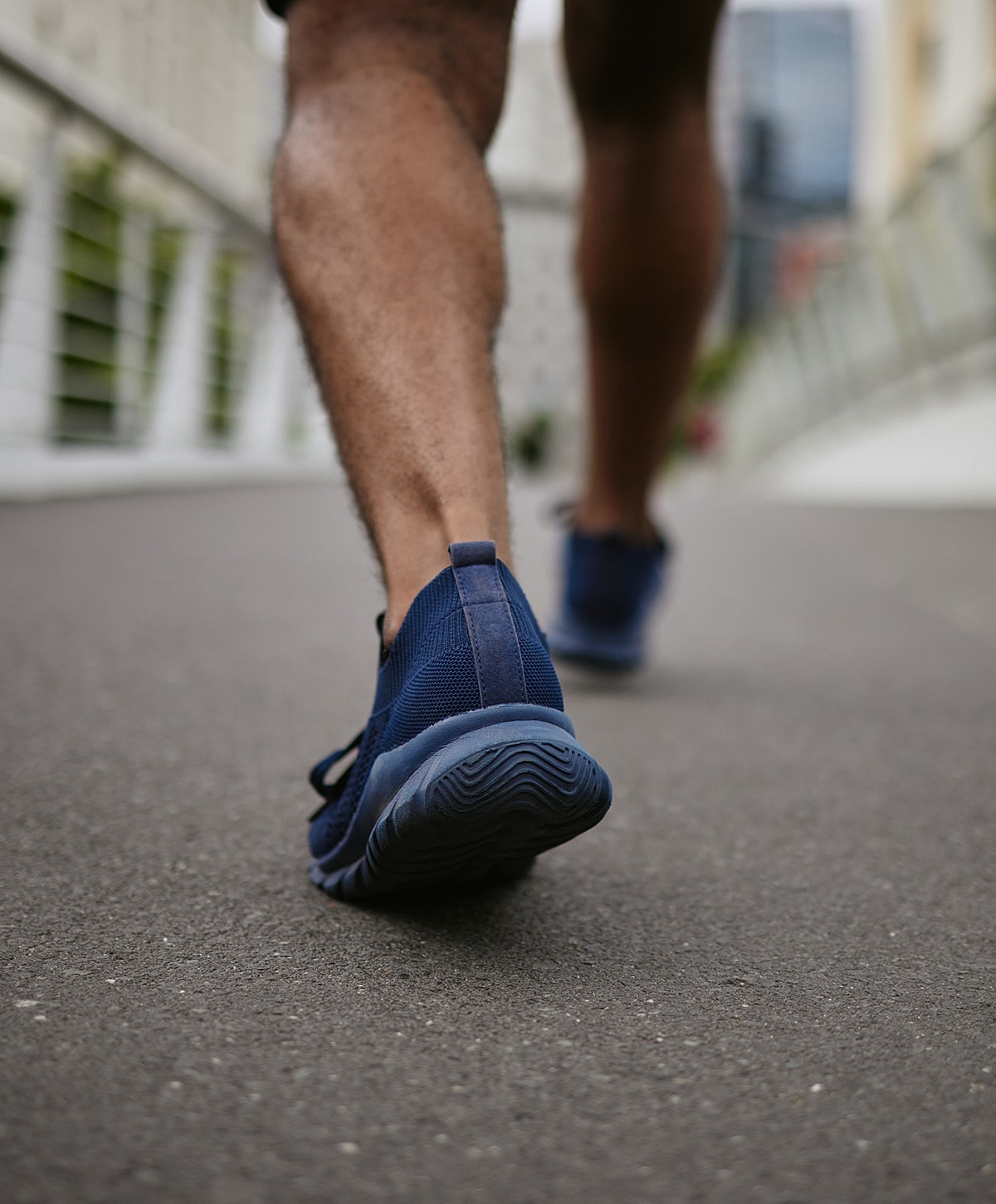 Person walking in blue athletic shoes.